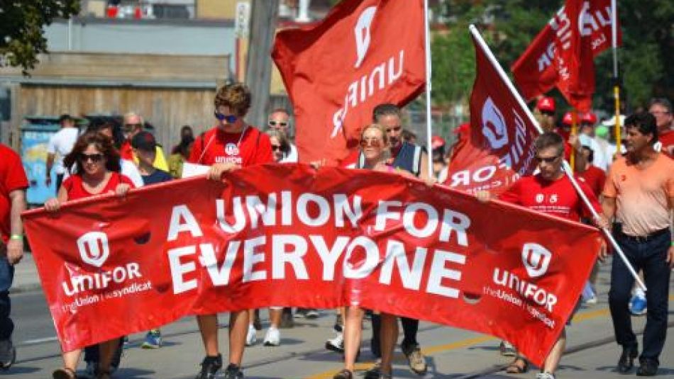 people in a parade holding a banner